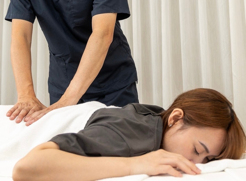 背中に手を添えながら行うCreaの整体